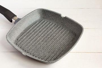 empty grill pan with non-stick coating on light background