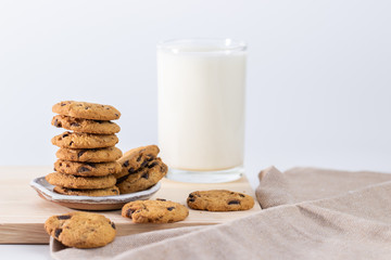 Cookies and fresh milk placed on a wooden plate on a white background, break snacks, chocolate chip cookies