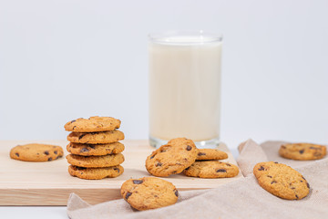 Cookies and fresh milk placed on a wooden plate on a white background, break snacks, chocolate chip cookies