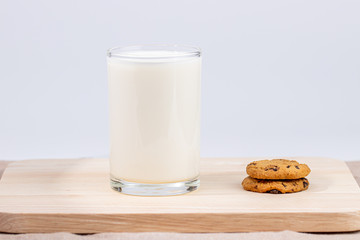 Cookies and fresh milk placed on a wooden plate on a white background, break snacks, chocolate chip cookies
