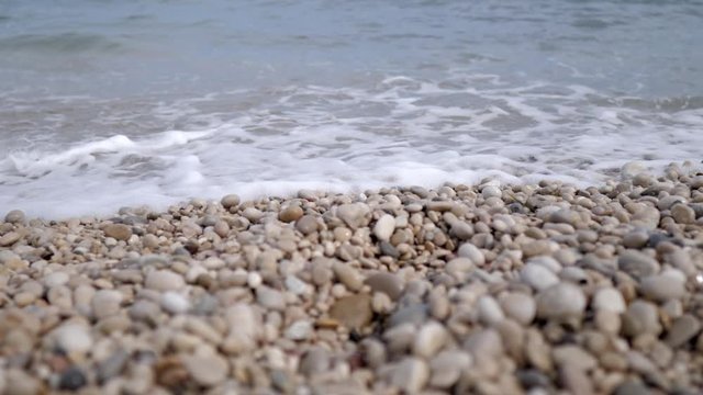 View at ground level of the beach with stones of Altea, Mediterranean sea in the province of Alicante. A sunny summer day.