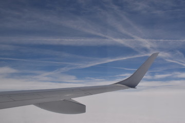 wing of an airplane flying above the clouds