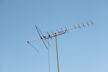 The old-fashioned TV antenna that rises to the blue sky