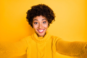 Photo of trendy cute nice stylish charming black girlfriend smiling toothily taking selfie isolated over yellow bright color background