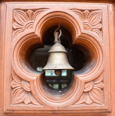 Obraz premium Bell in a wooden door at a Hindu temple