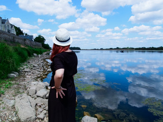 girl in a black and white hat by the river