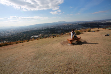 Fototapeta premium outdoor girl walk on the peak, have a good view on the top mountain range, to look far into the distance in good weather in Nara, Japan. clouds background