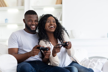 Happy Black Couple Enjoying Playing Video Games Together © Prostock-studio