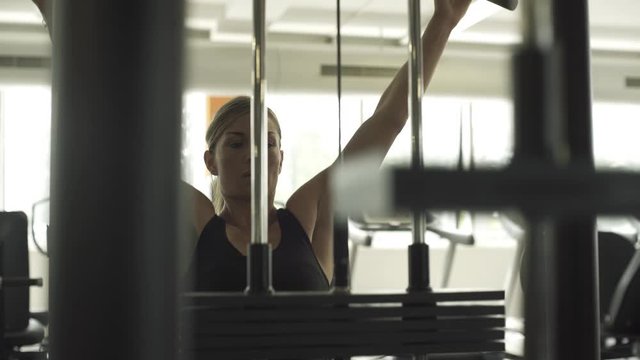 Fit woman exercising with a lat pulldown machine