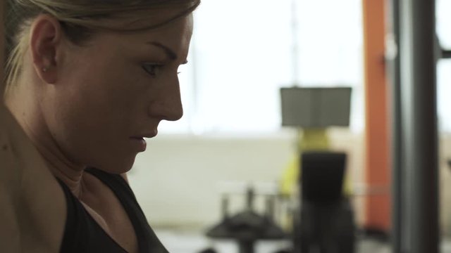 Fit woman exercising with a lat pulldown machine