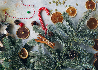 Christmas or New Year decoration, fir tree, candy cane, dry oranges, cones and cookie cutters