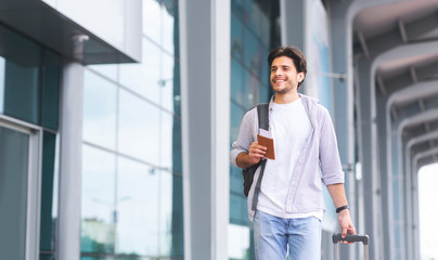 Cheerful guy going to flight registration, enjoying future travel