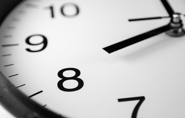 Close up of white analog clock hand with eight o'clock 