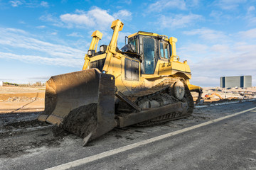 Machinery cleaning a mud road after a storm