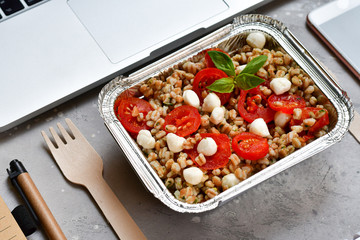 Food delivery. Lunch box with a diet lunch or breakfast or dinner on grey office table. takeaway lunch at the office. Top view . takeout healthy lunch. selective focus