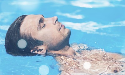 Photo of muscular Man relax in blue water of Swimming Pool.