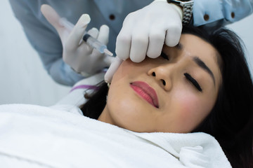 Naklejka premium A woman is doing cosmetic injection