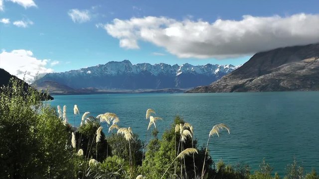 Time lapse of sunny day in Queenstown. Snow covered mountains and Lake Wakatipu, Otago. The Remarkables mountain range in the South Island of New Zealand. Full hd stock footage. Cloudscape.