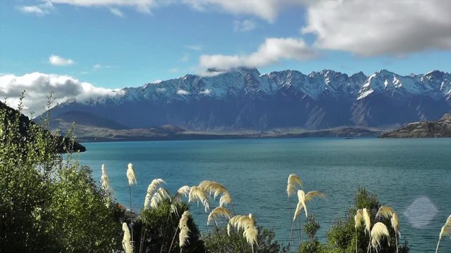Time lapse of sunny day in Queenstown. Snow covered mountains and Lake Wakatipu, Otago. The Remarkables mountain range in the South Island of New Zealand. Full hd stock footage. Cloudscape.