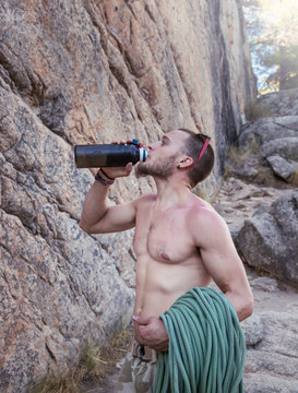 Jorge bebe agua antes de comenzar la escala una pared de La Pedriza, en la Sierra de Madrid