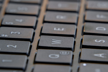 Black laptop keyboard. Image in escape of keys with a fixed point and out of focus.