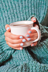 Female hands holding hot cup of coffee or tea.