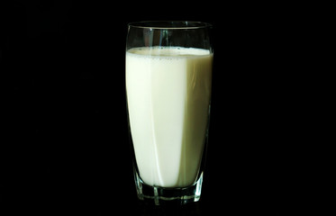 Glass of milk on a black background.