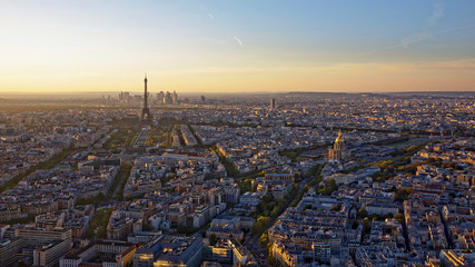 Aerial panormic view of Paris skyline with Eiffel Tower, Les Invalides and business district of Defense at orange sunset, as seen from Montparnasse Tower, Paris, France