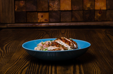 Mix sausage with fried potato and salad on wooden background