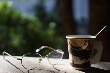 cup of coffee on wooden table in the garden