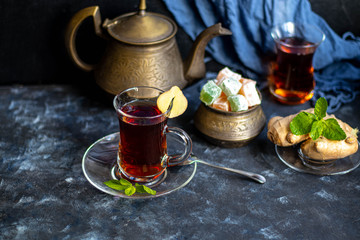Arabic, oriental tea with lemon. Warms on cold evenings, cools in the hot summer. Heals colds. Nearby lies a fresh root and lime green.