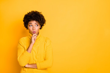 Copyspace photo of trendy charming cute interested curly wavy black girlfriend with lips pouted pondering over something wearing yellow pullover while isolated over vivid color background