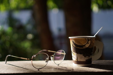 cup of coffee on wooden table in the garden