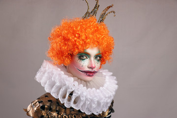 Red sad clown . Beautiful girl with bright clown makeup with red wig and painted smile. horizontal...