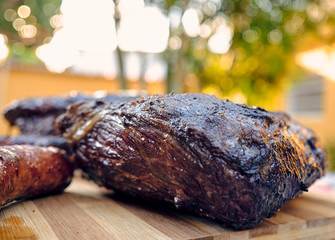 cooked pork ribs laid on a wooden table in a backyard