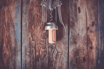 Corkscrew and cork on a rustic table