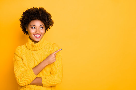Photo of dark skin lady indicating finger empty space wear warm knitted pullover isolated yellow background