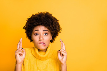 Photo of dark skin lady crossing fingers afraid to fail final exam wear warm knitted pullover isolated yellow background