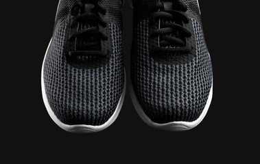 Sport shoes isolated on black background. Black sneakers running shoes. Casual shoes. Youth style. Shoes for fitness, running, yoga.
