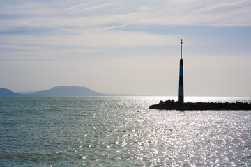 Lake Balaton, pier with beacon and the Badacsony mountain in the background