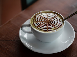 close up hot matcha green tee in white cup on wooden table, drink and beverage concept.