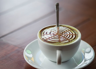 close up hot matcha green tee in white cup on wooden table, drink and beverage concept.