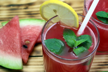 two glasses of watermelon juice with a straw