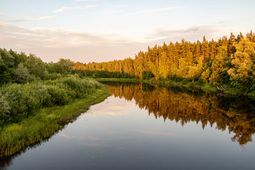 View to river Gauja and tree reflections shortly before sunset  in Strenci nature trail in Latvia