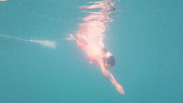 ragazza si tuffa in mare aperto, ripresa subacquea