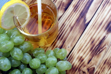 Glass of fresh grape juice with grapes on the background