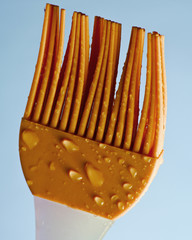 Silicone kitchen brush for cooking in drops of water on blue background