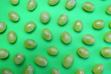 texture of fresh green grapes lies on a green background
