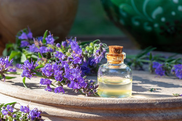 Obraz na płótnie Canvas A bottle of essential oil with hyssop flowers