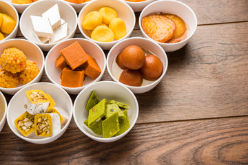 Fototapeta na wymiar Rangoli of Assorted Indian sweets/mithai in bowl for Diwali or any other festivals, selective focus